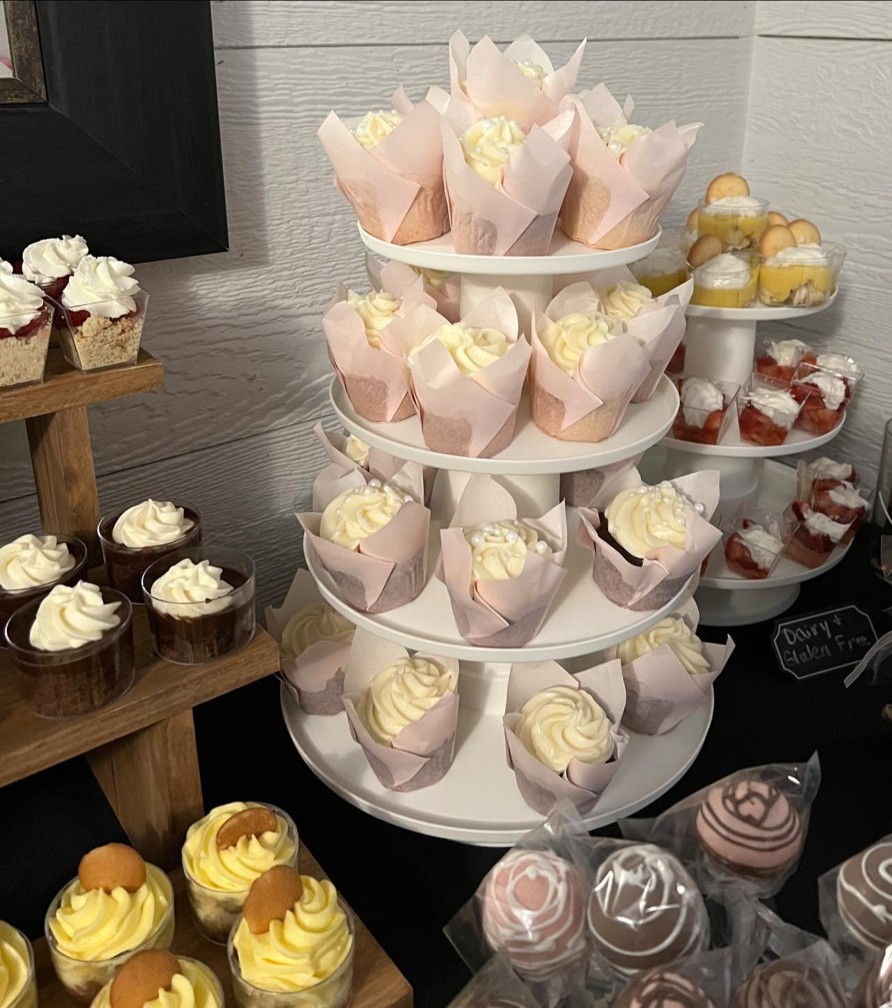 Event dessert table with cupcakes, pudding cups, and sweet treats